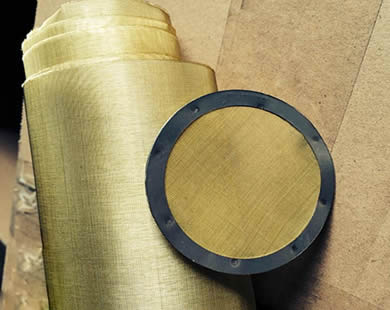 Um rolo da rede de arame de bronze e um disco de bronze redondo do filtro com borda de envolvimento de borracha são colocados junto.